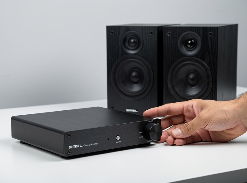 Budget SMSL Class D amplifier next to bookshelf speakers