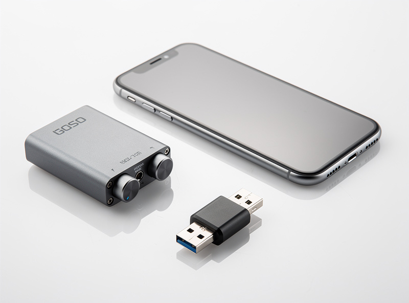 Portable headphone amplifier next to smartphone