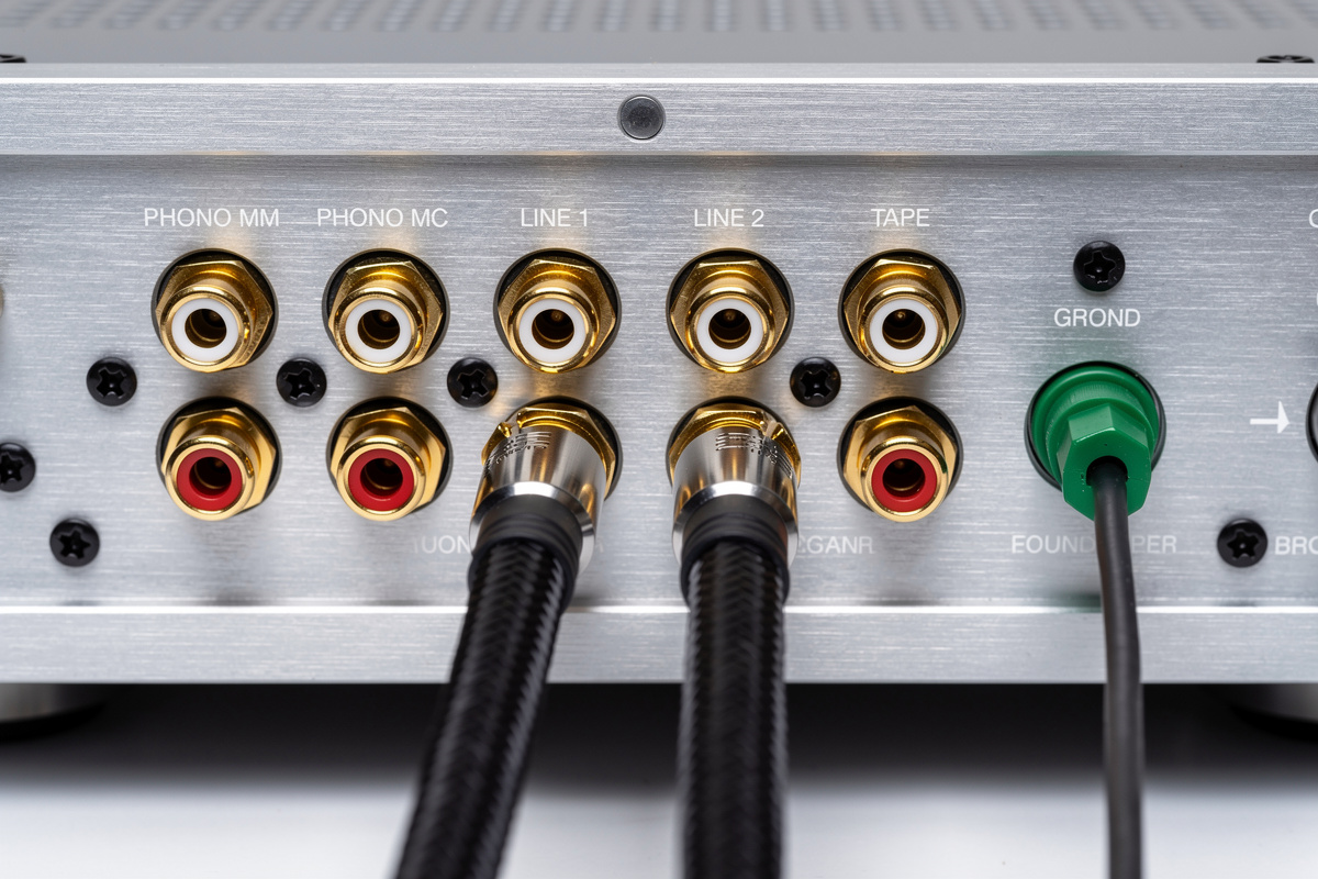 Integrated amplifier rear panel showing PHONO MM, PHONO MC, and LINE inputs with grounded turntable