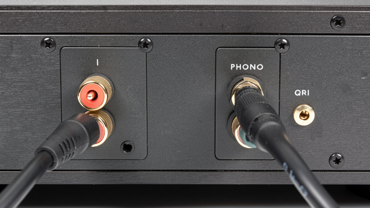 Turntable connected to a stereo integrated amplifier with RCA cables and a ground wire