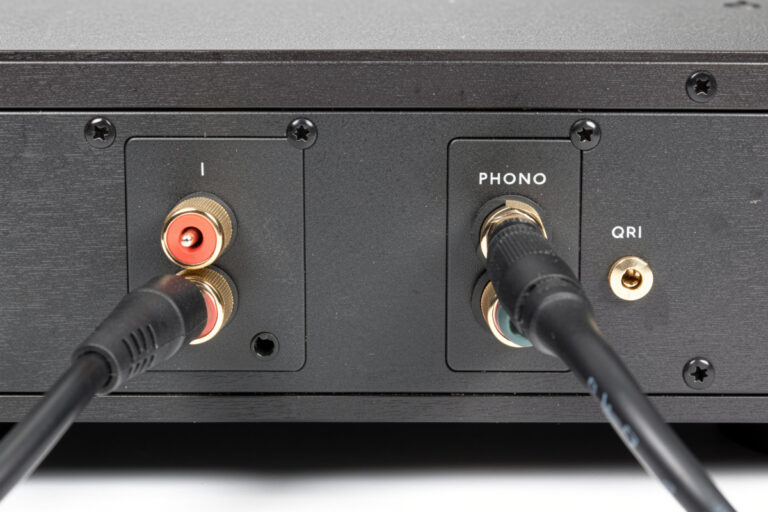 Turntable connected to a stereo integrated amplifier with RCA cables and a ground wire