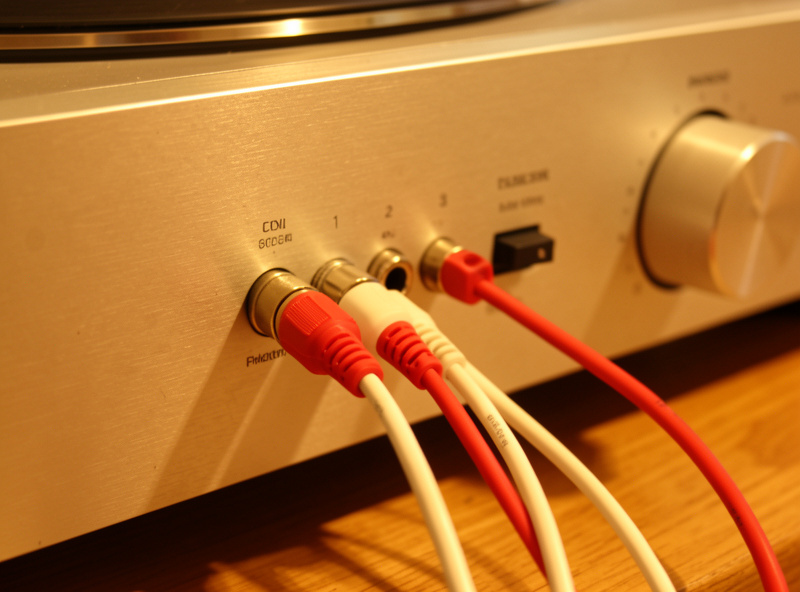 Turntable RCA leads and ground wire plugged into the phono input of a stereo amplifier